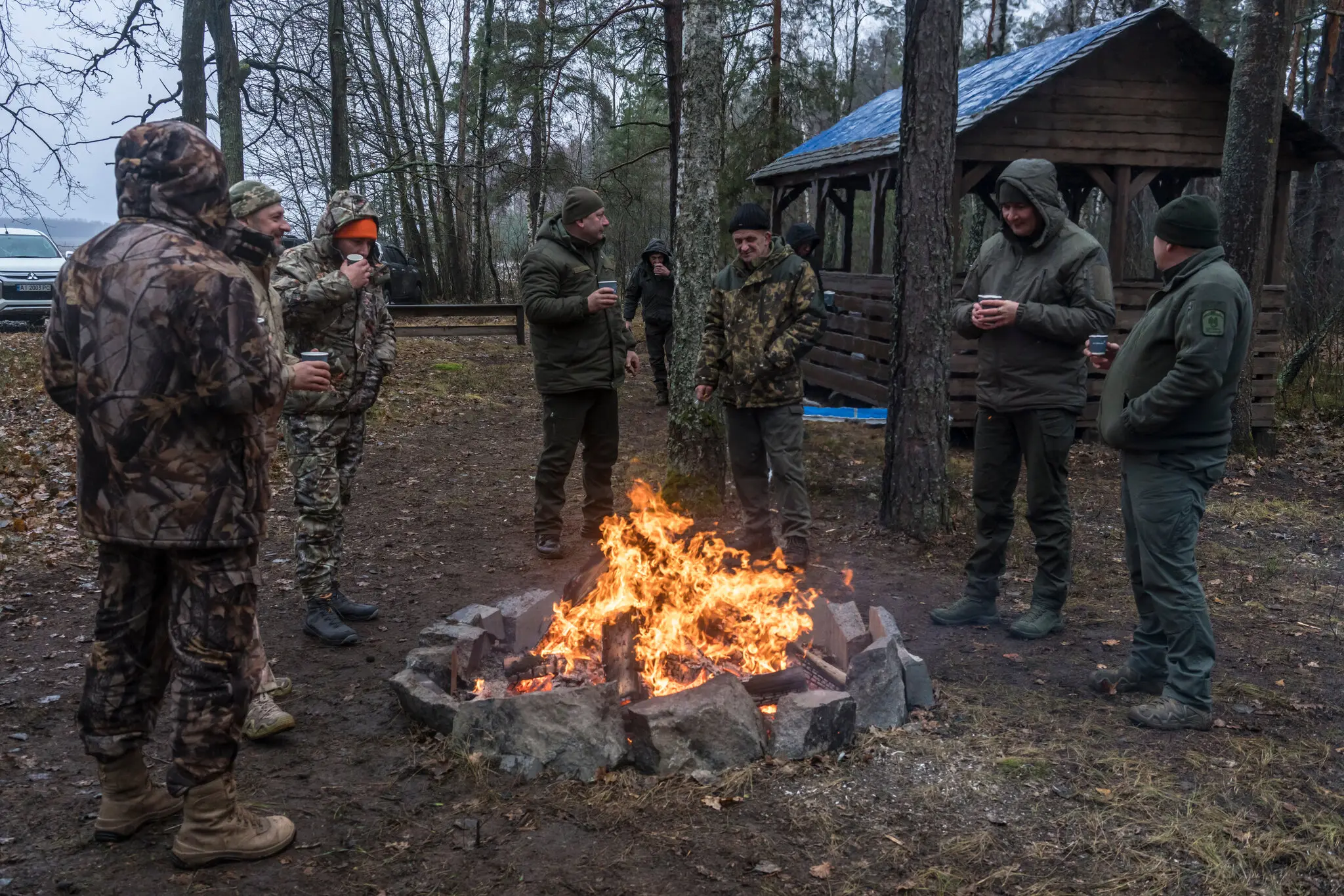 Мисливці гріються біля вогнища перед відстрілом оленів, кабанів, лисиць і вовків у Меньківці, Україна, 7 грудня.